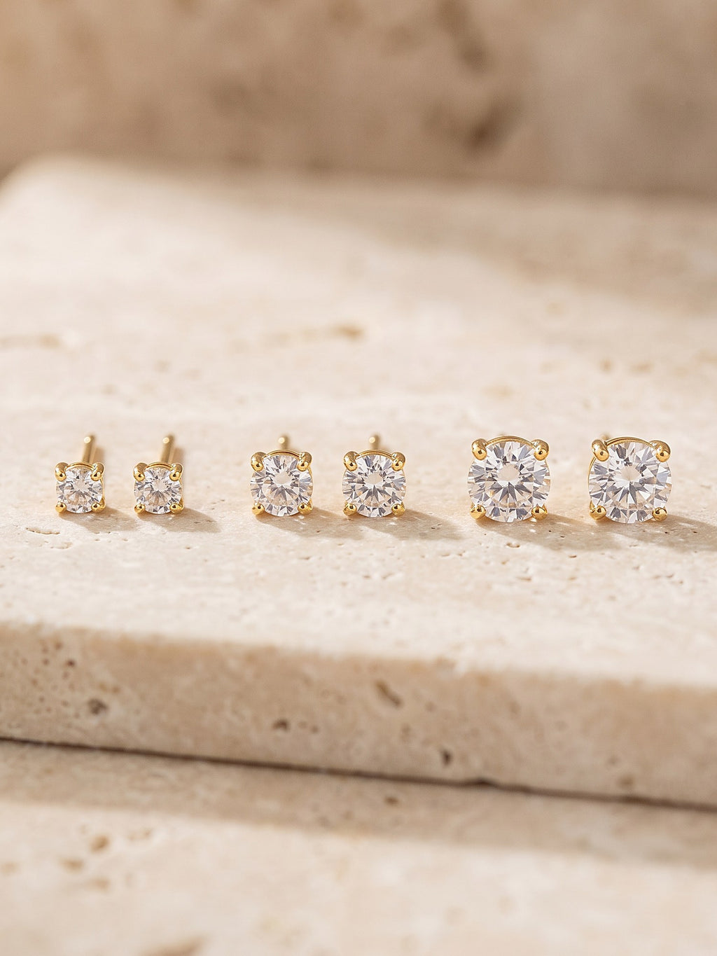 Close-up of the four-claw setting and cubic zirconia stone of a gold stud earring