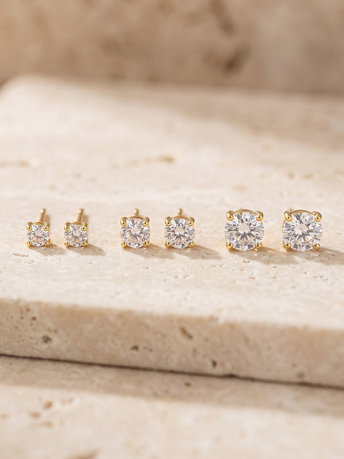 Close-up of the four-claw setting and cubic zirconia stone of a gold stud earring