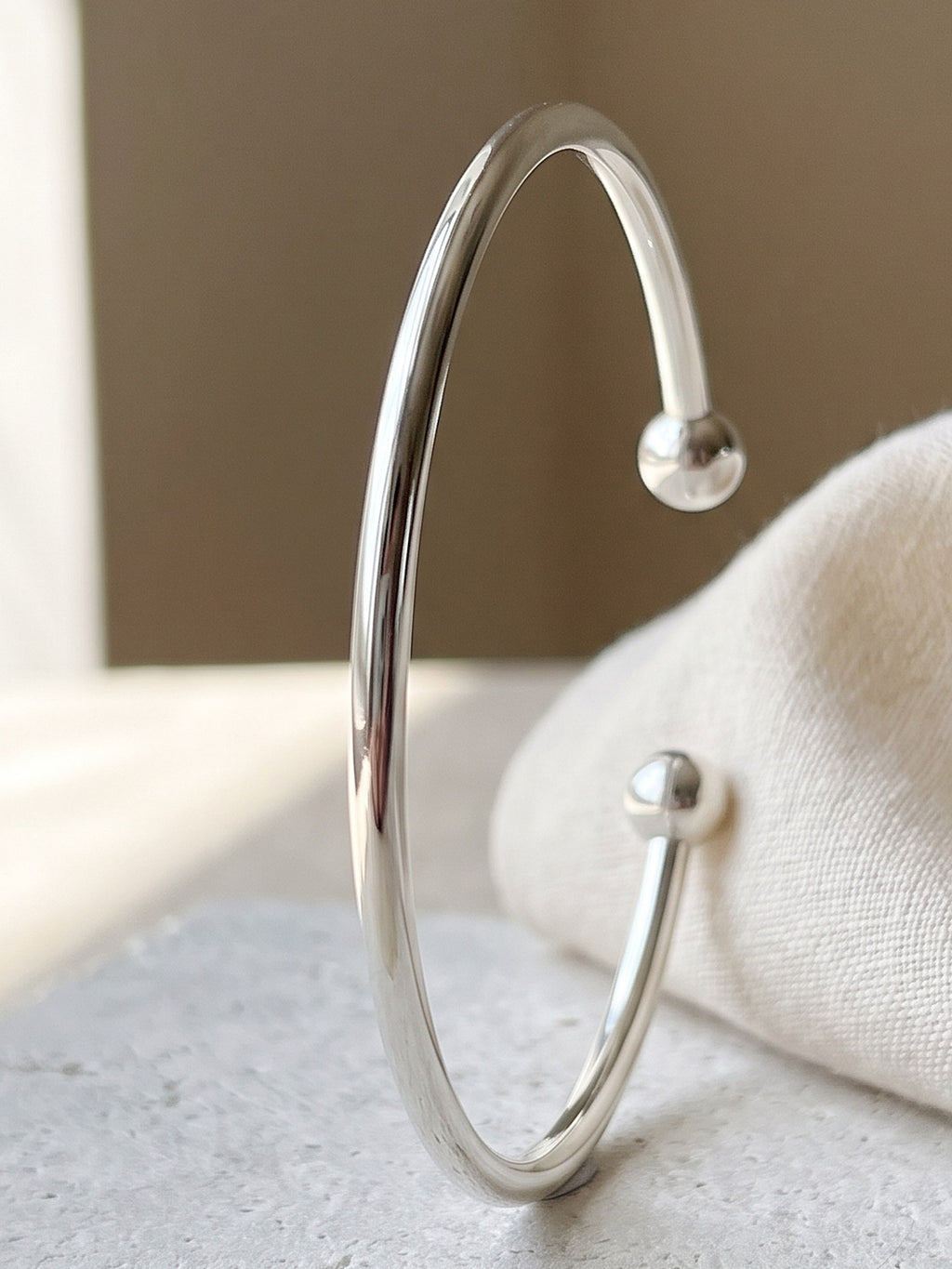 Close-up of the rounded ends and polished wire of the silver open cuff