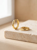 Pair of Mini Huggie Hoop Earrings in gold vermeil on cream travertine stone