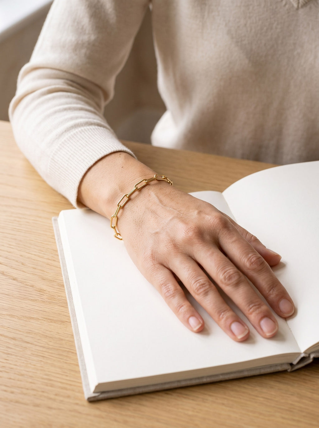 Woman wearing the gold Paperclip Chain Bracelet on her wrist