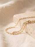Paperclip Chain Necklace in gold vermeil draped over cream travertine stone