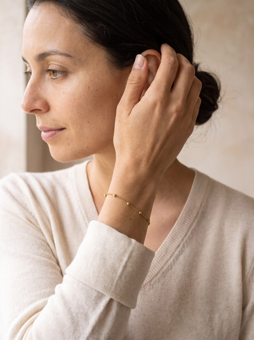 Woman wearing the gold Satellite Chain Bracelet on her wrist